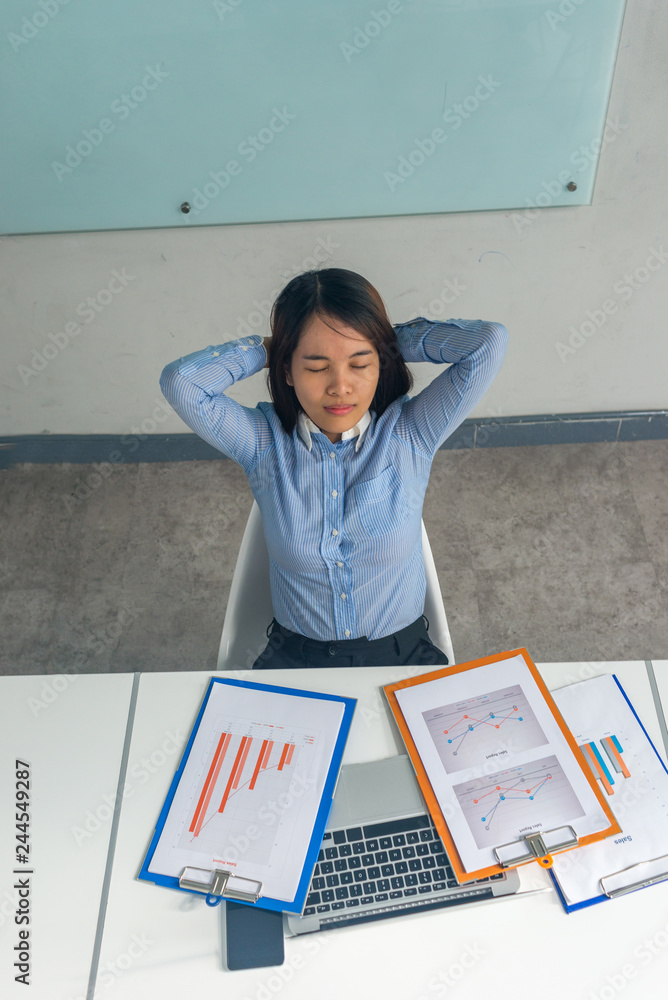Young businesswoman accountant sleeping with financial reports and paper folders in the business office Young businesswoman accountant sleeping with financial reports and paper folders in the business office