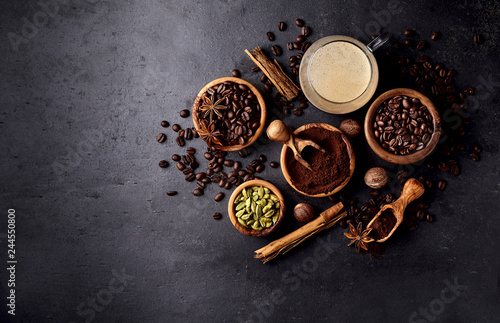 Coffee, anise, cardamon and nutmeg on black background.