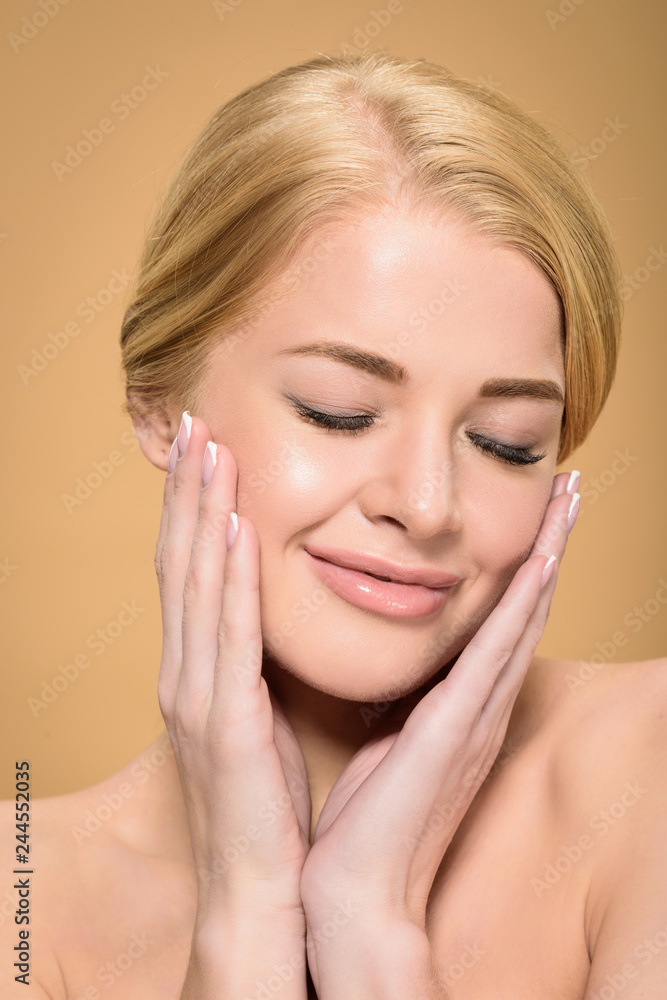 beautiful happy naked girl touching face with hands and smiling isolated on beige beautiful happy naked girl touching face with hands and smiling isolated on beige