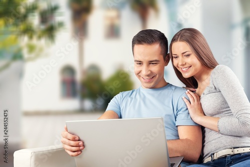 Young business couple using laptop at home, online shopping with