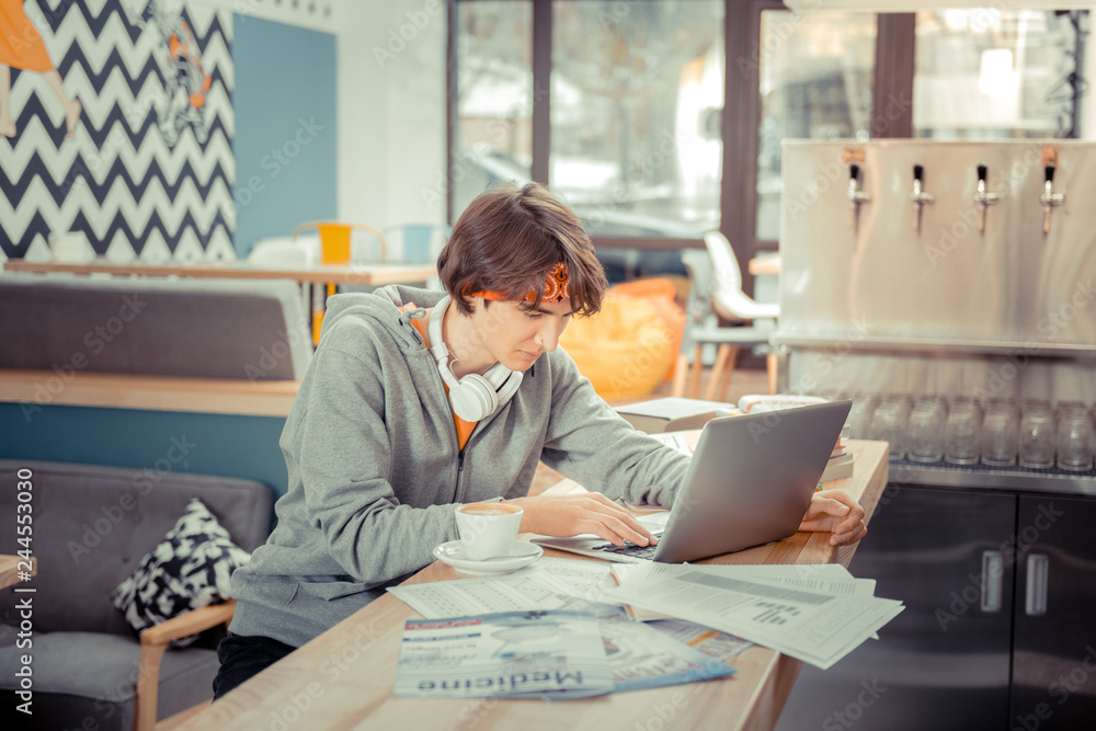 Student doing his hometask sitting in a favourite cafe Student doing his hometask sitting in a favourite cafe