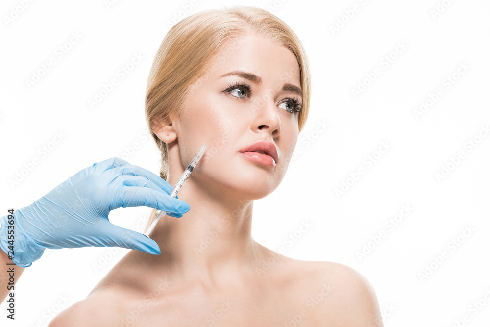 cropped shot of cosmetologist in latex glove making beauty injection to naked young woman isolated on white