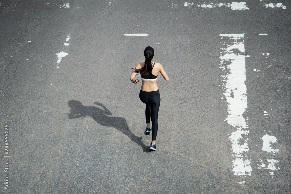 Fitness woman she is running the road. Top view Fitness woman she is running the road. Top view