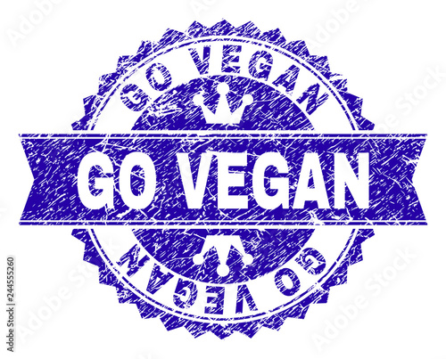 GO VEGAN rosette stamp overlay with grunge texture. Designed with round rosette, ribbon and small crowns. Blue vector rubber watermark of GO VEGAN label with dirty texture.