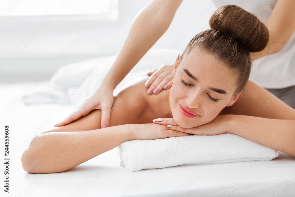 Beautiful woman enjoying shoulder massage in health spa Beautiful woman enjoying shoulder massage in health spa