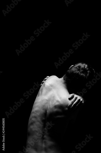 black and white photo of a man from the back light falls from above