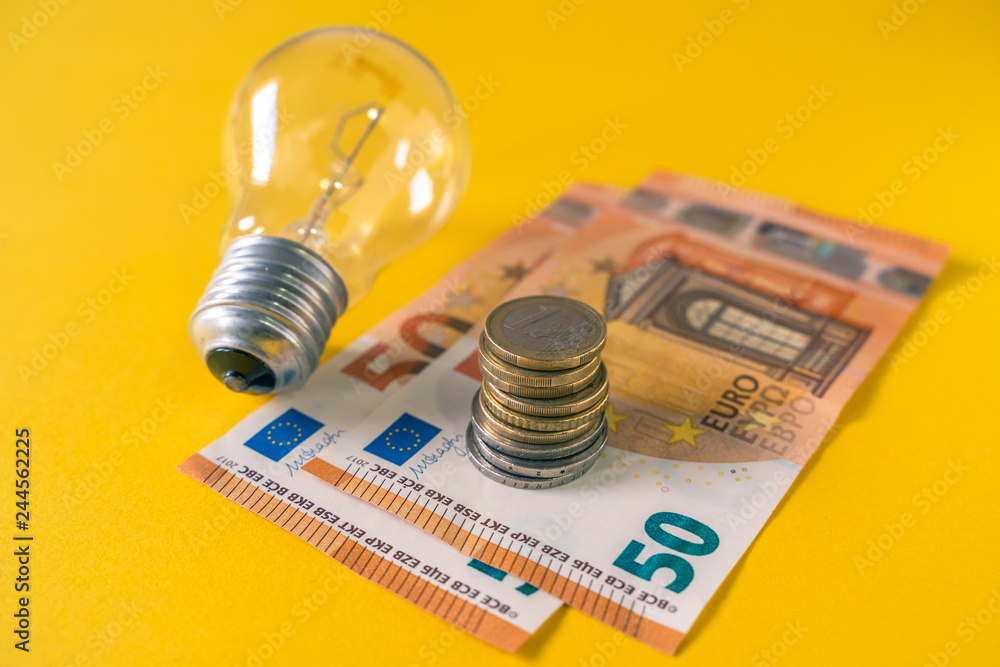Light Bulb and european banknotes and coins. E27. Coiled tungsten filaments. Light Bulb and european banknotes and coins. E27. Coiled tungsten filaments.