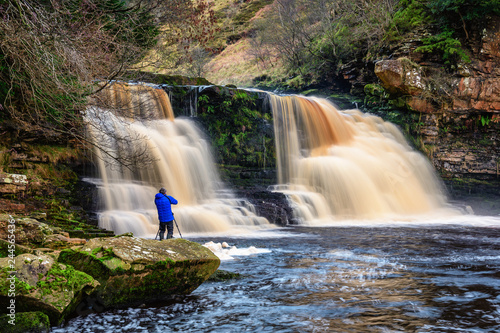 Photographer at Crammel Linn Waterfall  as the River Irthing flows over the 10 metre falls it marks the boundary between Northumberland and Cumbria just north of Gilsland  England
