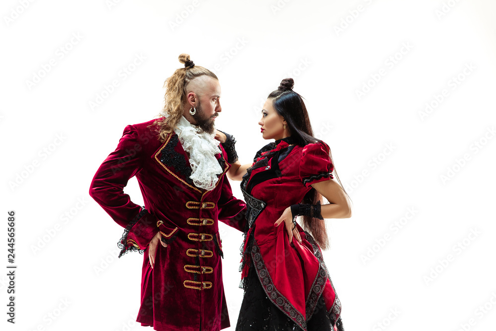 The young man wearing a traditional medieval costume of marquis posing at studio with woman as marquise. Fantasy, Antique, Renaissance concept