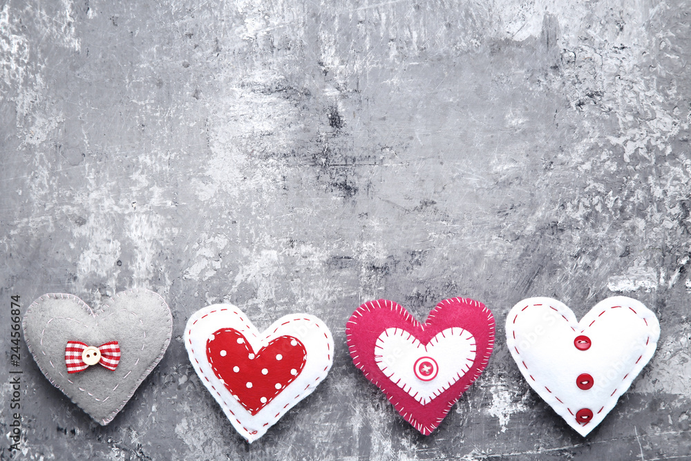 Colorful fabric hearts on grey wooden table Colorful fabric hearts on grey wooden table