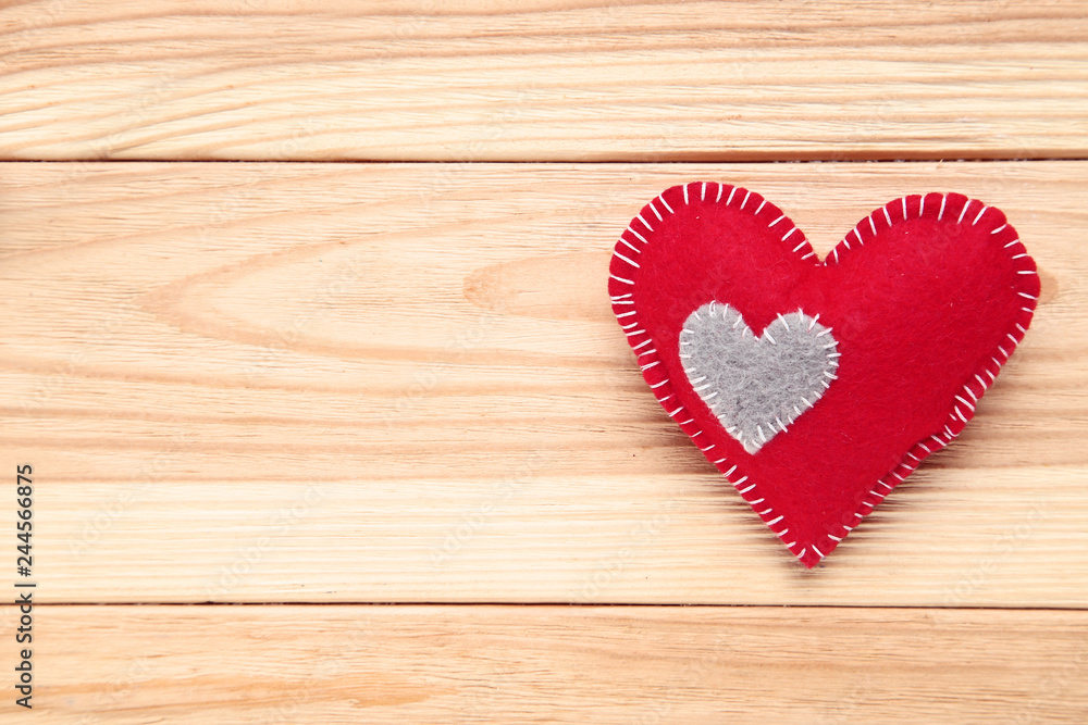 Red fabric heart on brown wooden table Red fabric heart on brown wooden table