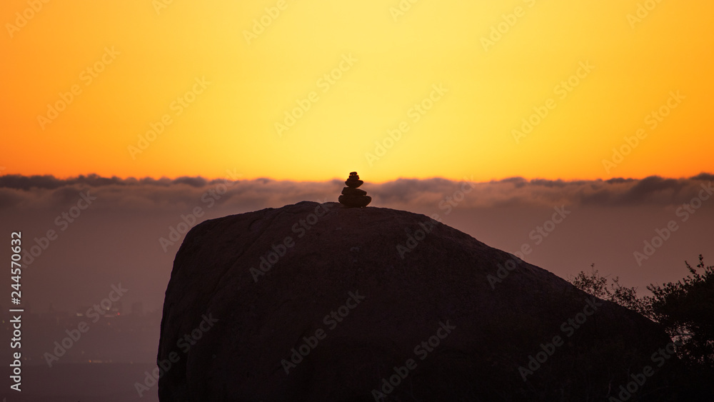stack of rocks in front of sea of clouds