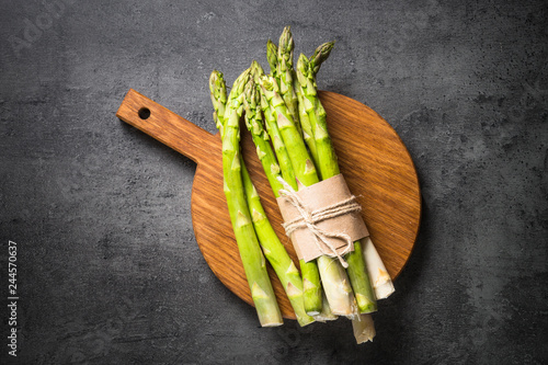 Fresh green asparagus on black slate background.