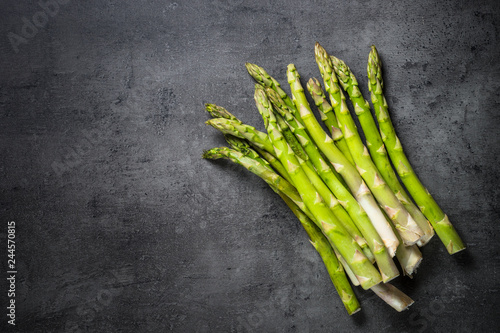 Photography Fresh green asparagus on black slate background.