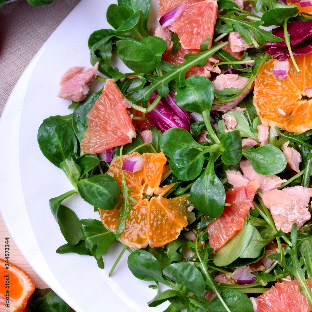 Salad with radicchio, mandarins, red oranges and canned tuna on a white plate Salad with radicchio, mandarins, red oranges and canned tuna on a white plate