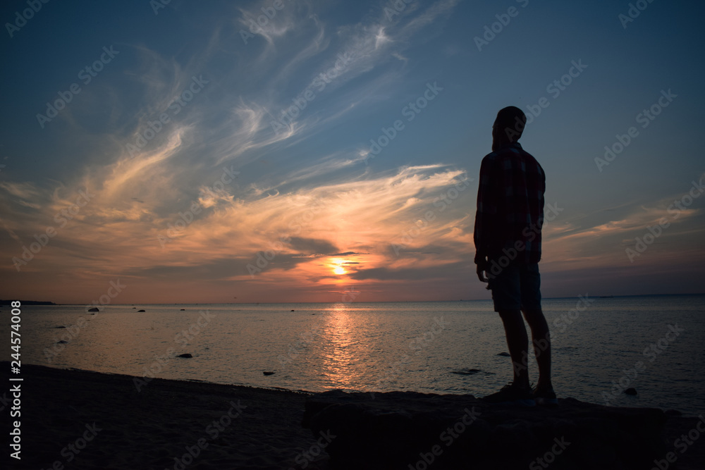 silhouette of man at sunset near the bay