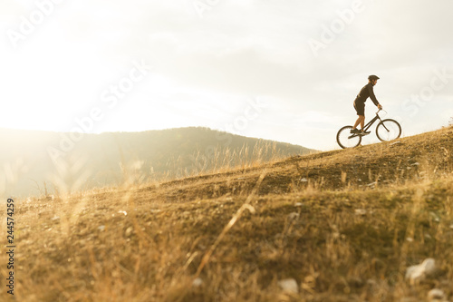 Anonymous sportsman on bicycle riding up hill