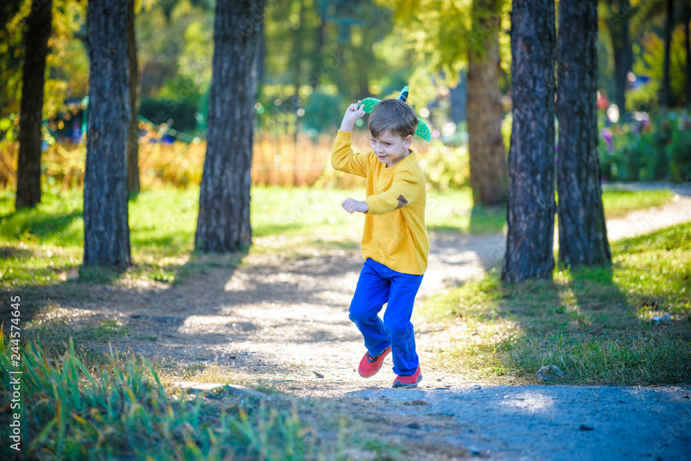 Happy kid playing with toy airplane against blue summer sky background. Boy throw foam plane in the forest or park. Best childhood concept Happy kid playing with toy airplane against blue summer sky background. Boy throw foam plane in the forest or park. Best childhood concept