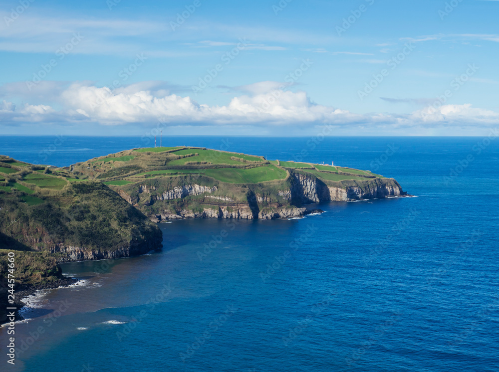 green fields pasture and coastal cliffs and blue ocean and sky horizon at north coast of sao miguel island, Azores, Portugal