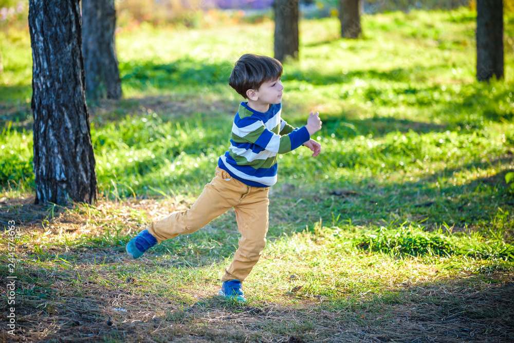 Happy kid playing with toy airplane against blue summer sky background. Boy throw foam plane in the forest or park. Best childhood concept Happy kid playing with toy airplane against blue summer sky background. Boy throw foam plane in the forest or park. Best childhood concept