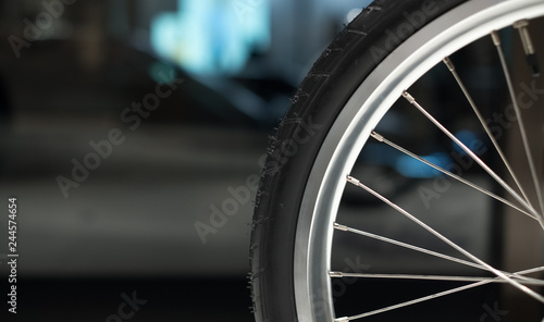 Close up of bicycle wheel and spokes with bokeh in the background