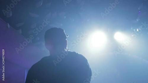 young man is reading rap on the stage. A Young Man Under The Spotlight With The Rap Scene