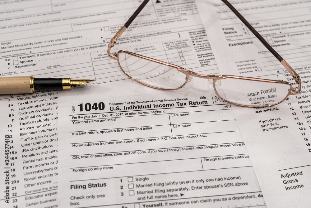 Individual tax form 1040 with pen and glasses Individual tax form 1040 with pen and glasses