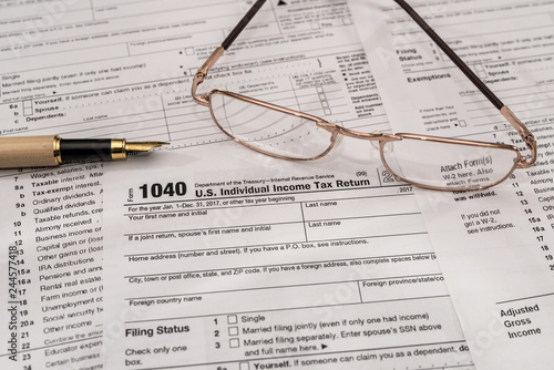 Individual tax form 1040 with pen and glasses