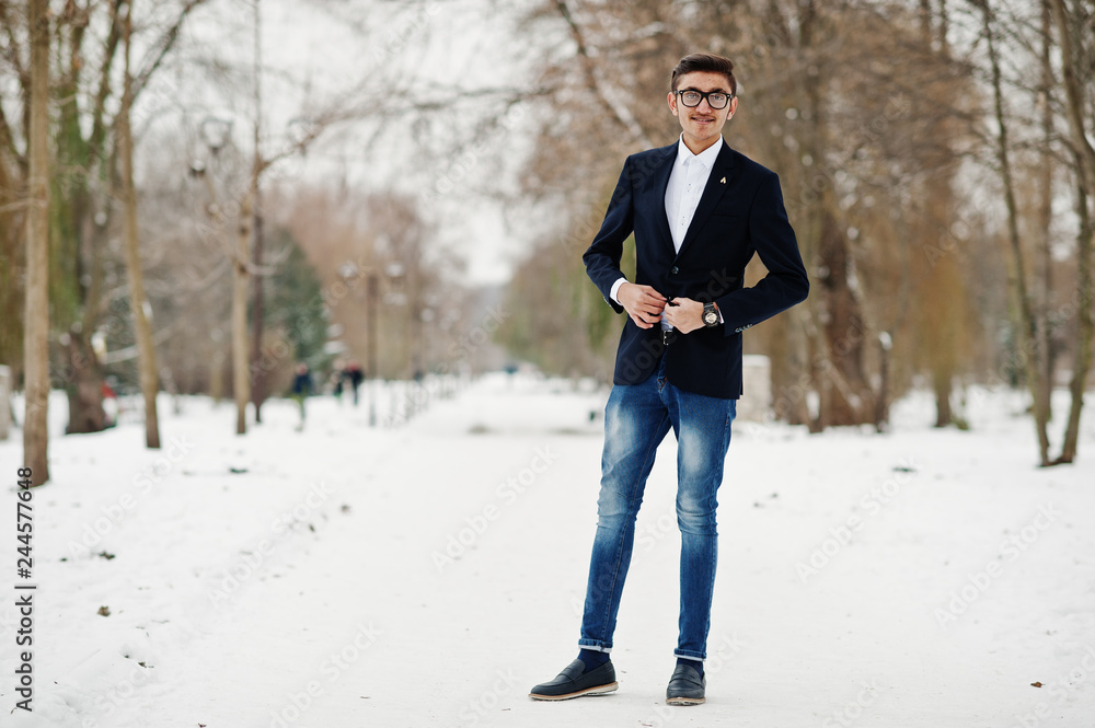 Stylish indian student man in suit and glasses posed at winter day outdoor. Stylish indian student man in suit and glasses posed at winter day outdoor.