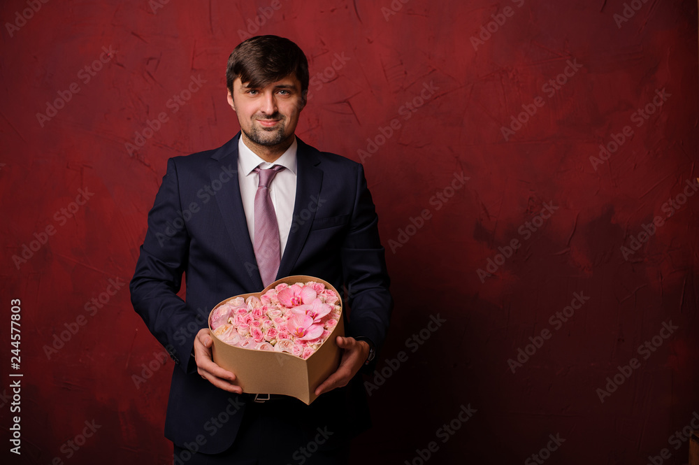 Man holding in a hand a box of pink beautiful flowers