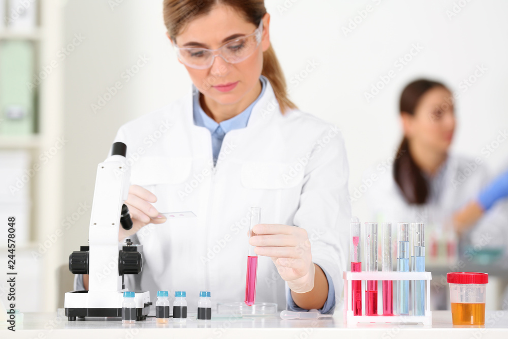 Female scientist working at table in laboratory. Research and analysis Female scientist working at table in laboratory. Research and analysis