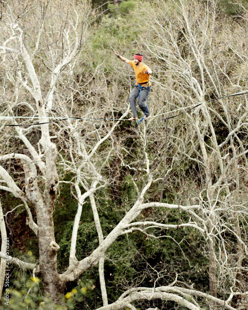 Highliner on a rope. Highline on a background of mountains. Extreme sport on the nature. Balancing on the sling. Equilibrium at altitude. Highliner on a rope. Highline on a background of mountains. Extreme sport on the nature. Balancing on the sling. Equilibrium at altitude.