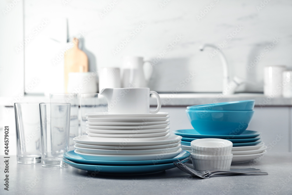 Fototapeta premium Set of clean dishes and cutlery on table in kitchen