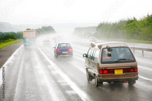 Traffics on a rainy wet highway in fog water spray