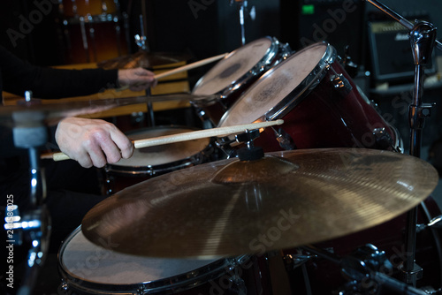 Professional drum set closeup. Drummer with drumsticks playing drums and cymbals  on the live music rock concert or in recording studio   