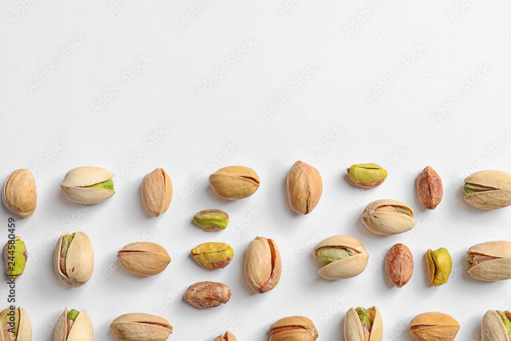Composition with organic pistachio nuts on white background, top view. Space for text