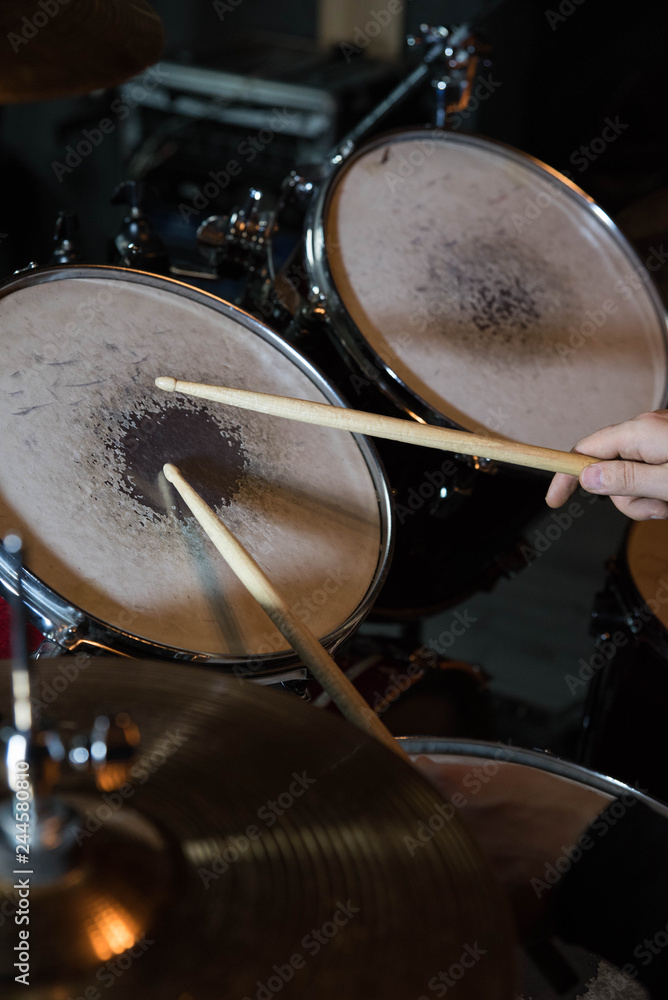 Fototapeta premium Professional drum set closeup. Drummer with drumsticks playing drums and cymbals, on the live music rock concert or in recording studio 