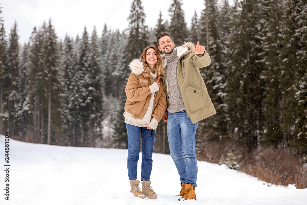 Fototapeta premium Couple spending time outdoors on snowy day. Winter vacation