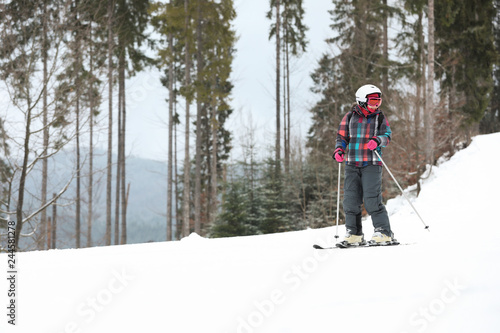 Skier on slope at resort, space for text. Winter vacation