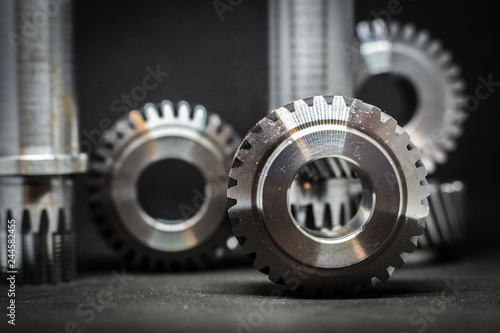 verschiedene Zahnräder aus Stahl Metal Silber nebeneinander platziert alle Zahnradarten mit dunklen Hintergrund