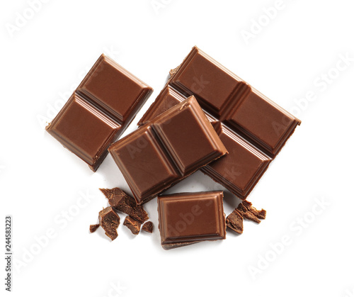 Pieces of tasty milk chocolate on white background, top view