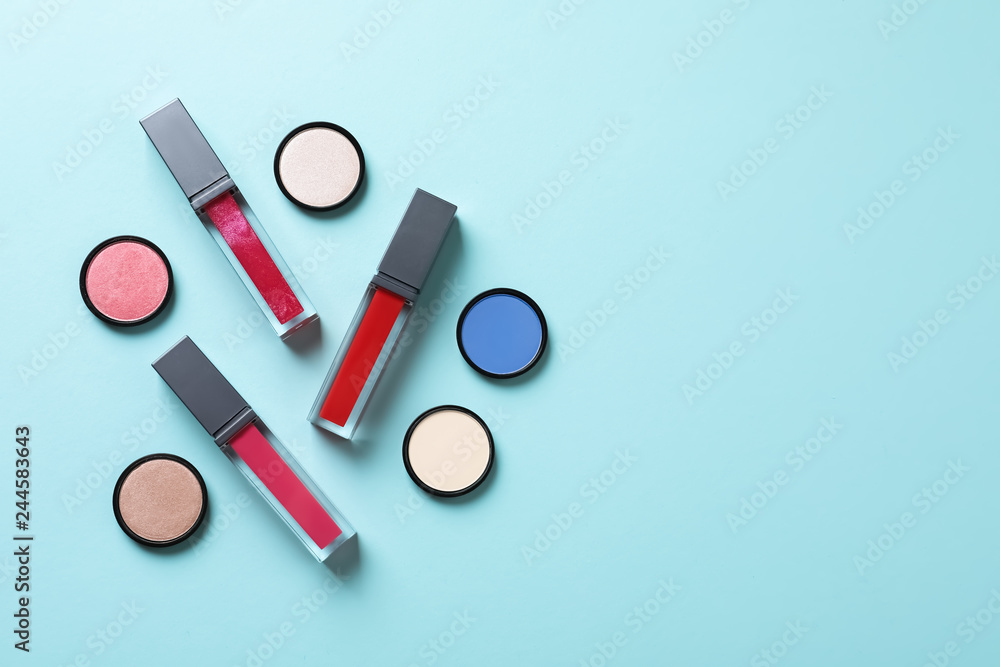 Composition of lipsticks and eyeshadows on color background, flat lay. Space for text Composition of lipsticks and eyeshadows on color background, flat lay. Space for text