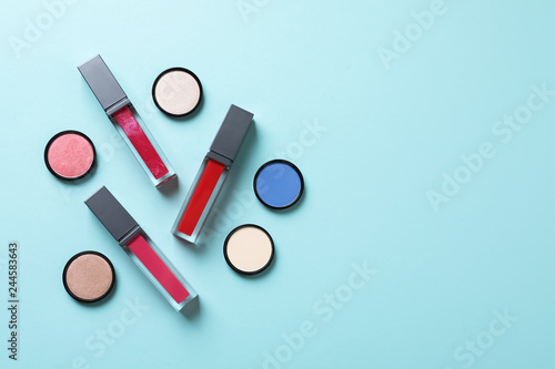 Composition of lipsticks and eyeshadows on color background, flat lay. Space for text