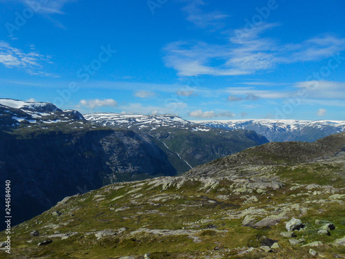 Popular tourist attraction near Trolltunga in sunny weather. View from the Trolltunga trail. Mountain lake Ringedalsvatnet. Norwegian landscape in sunny weather