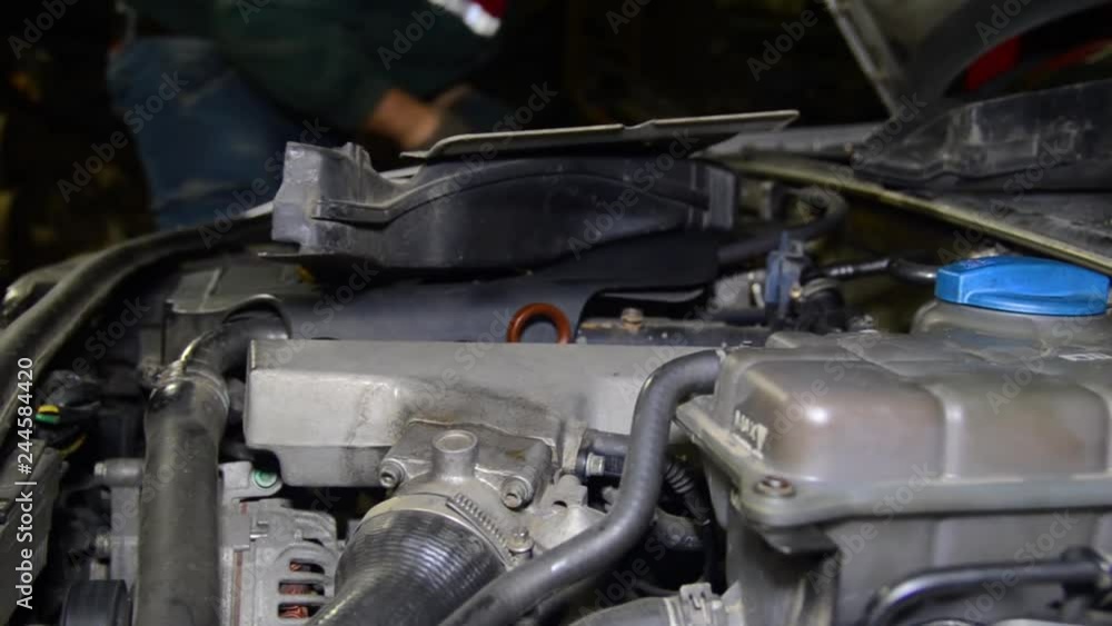 Auto mechanic working in the garage. Repair service. repairs under the hood. Auto mechanic working in the garage. Repair service. repairs under the hood.