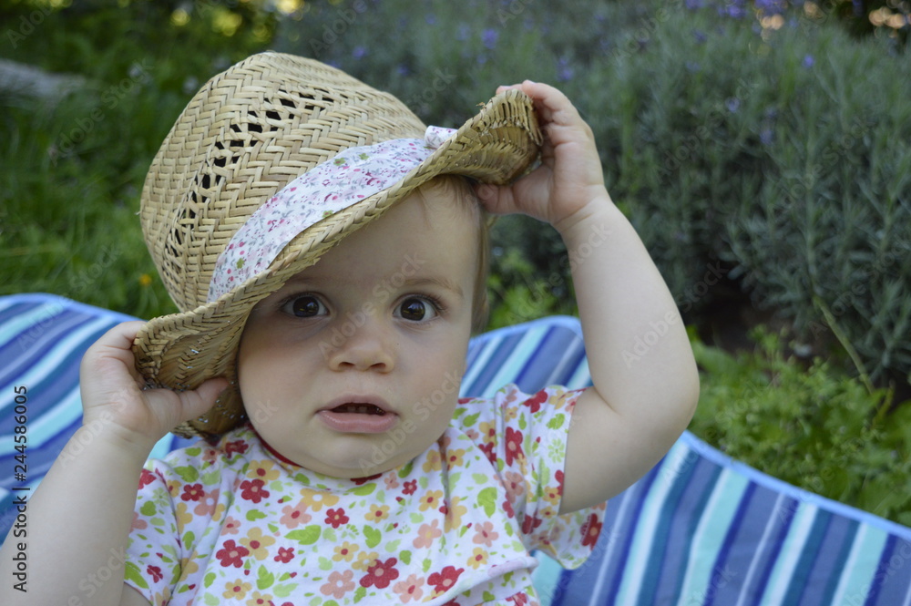 Closeup chubby little baby girl playing with straw hut on blurred background Closeup chubby little baby girl playing with straw hut on blurred background