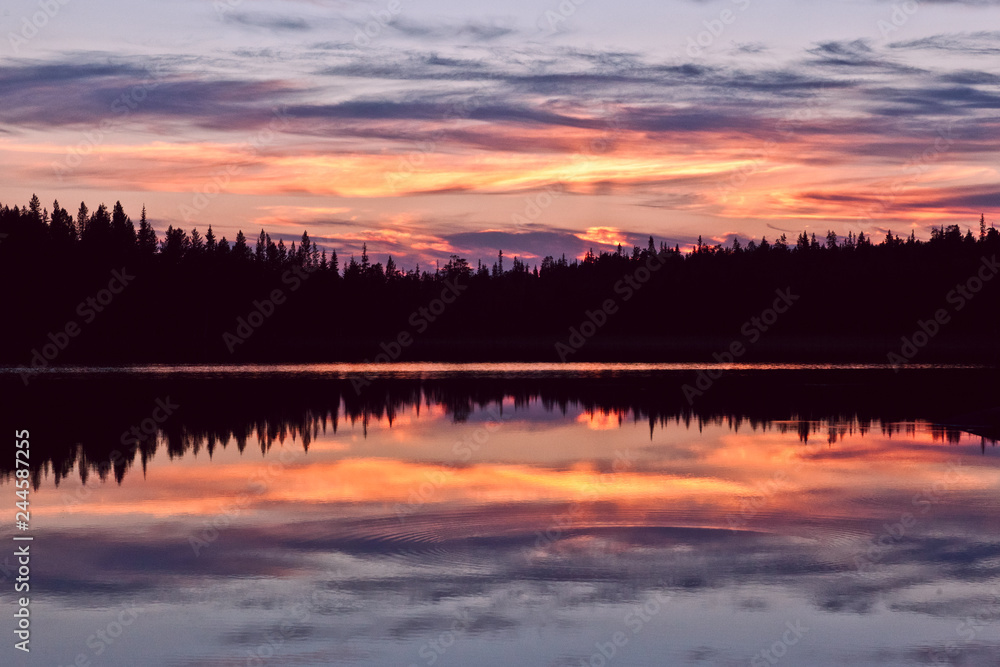 sunset clouds are reflected in the calm mirror water of the lake sunset clouds are reflected in the calm mirror water of the lake