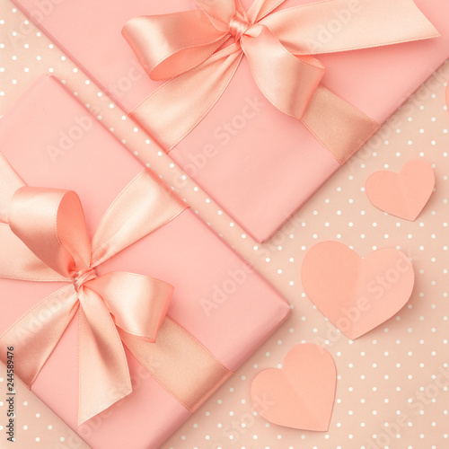 Valentine day idea composition: pink or coral present box with ribbon and small hearts on living coral background. Top view. Flat lay © Dzha