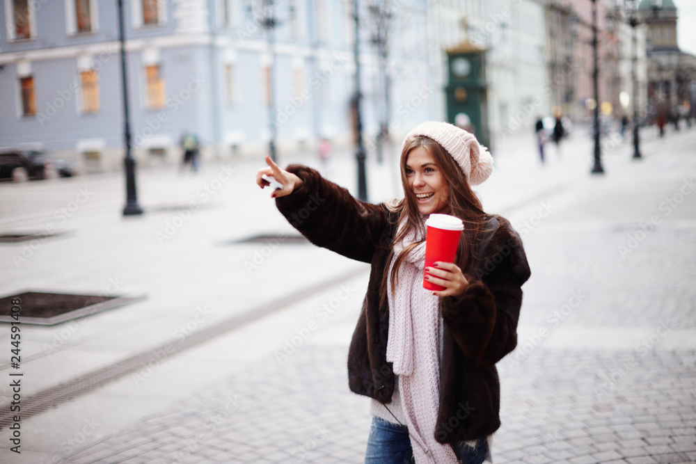 Brunette girl posing for photo in city streets with Christmas mood