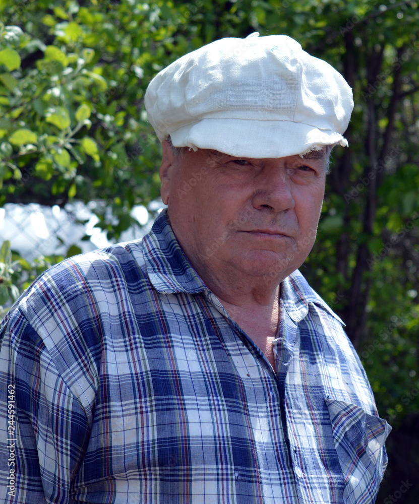 an elderly man in a cap doing the cooking in the garden an elderly man in a cap doing the cooking in the garden